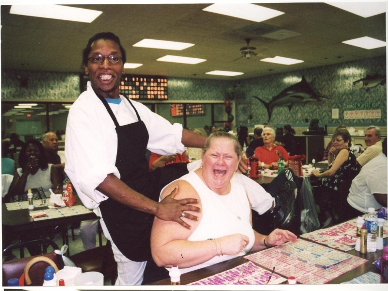 A man standing over an excited women playing bingo
