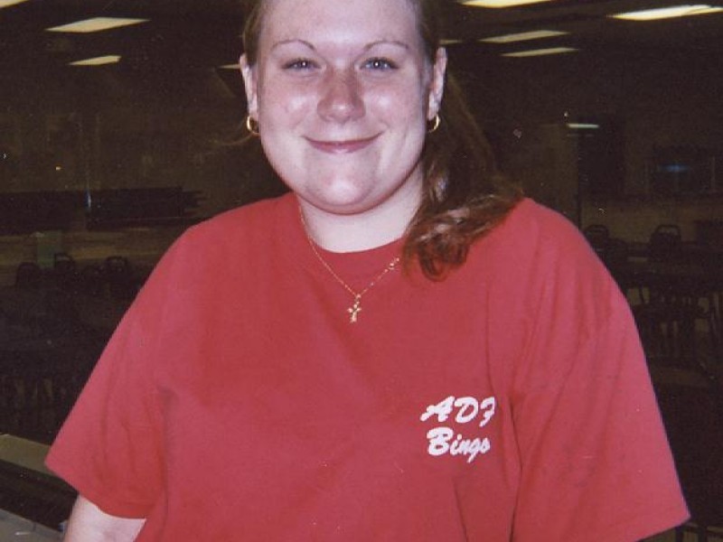 A woman in a red shirt smiling