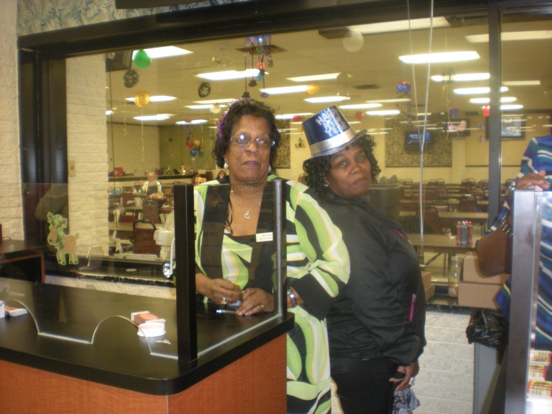 women pose behind counter