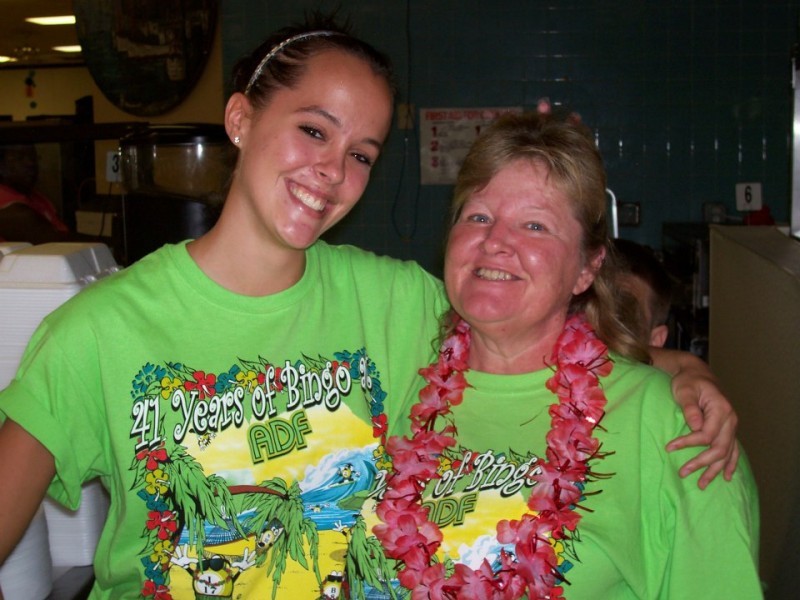 a pair of women hug in lime green shirts