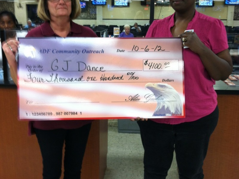 two women display a large american flag check