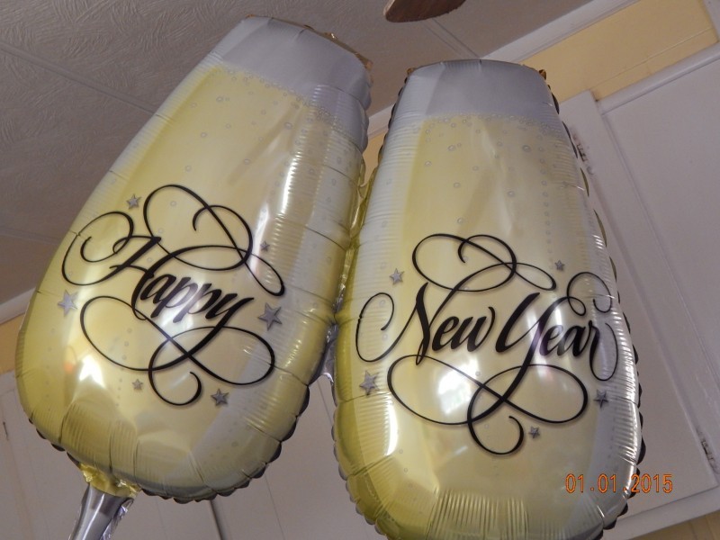 cheers glasses as new years balloons 