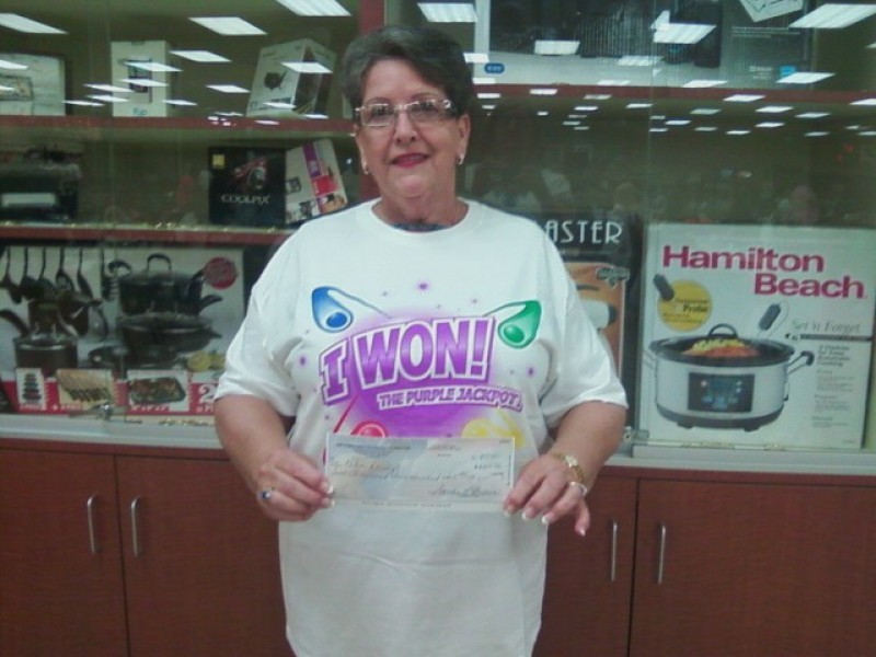 woman in I won shirt holds a check