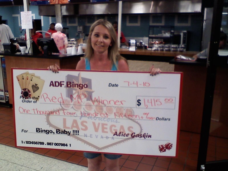 smiling woman shows large bingo check