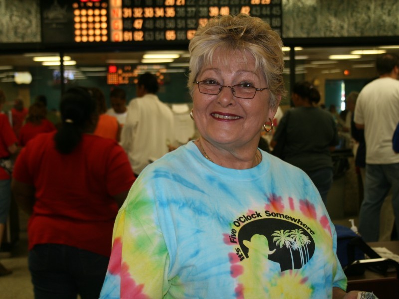 a woman in tie dye shirt with short hair smiles at camera