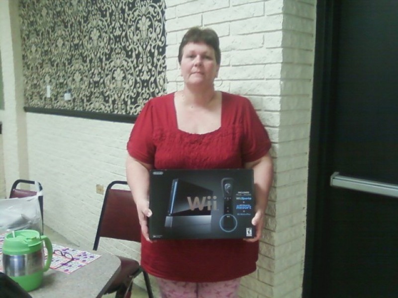 woman poses with a wii prize
