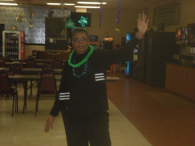 woman in black with green lei and green star headwear