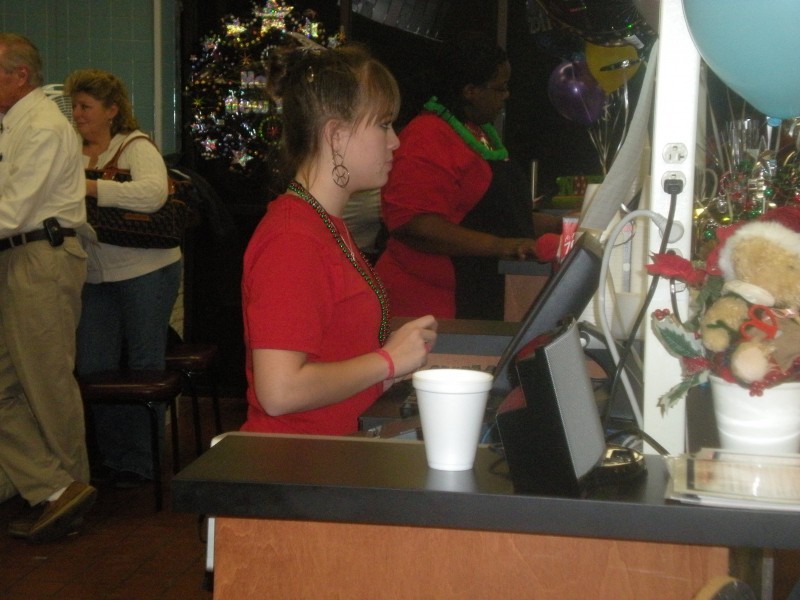 women stand behind cash registers 