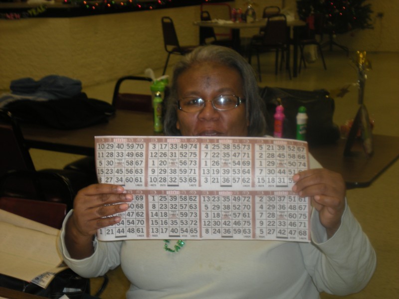 woman holds up a set of bingo cards