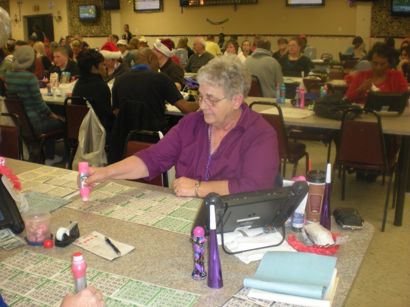 woman stamps bingo cards with pink stamp