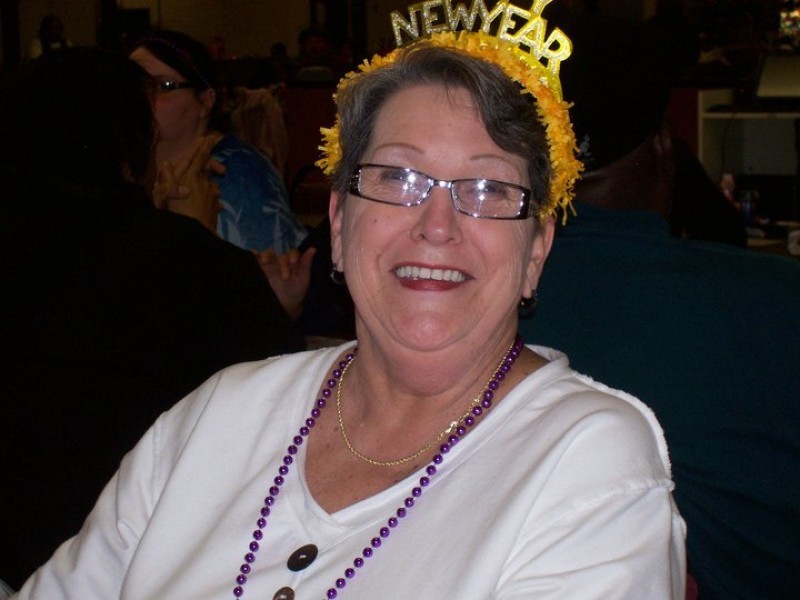 woman with glasses and yellow new years head gear